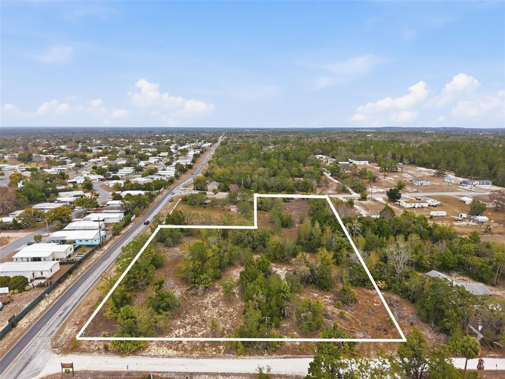 An aerial view shows a vacant, wooded lot outlined in white next to a road — 0 WEEPING WILLOW ROAD, BROOKSVILLE, FL