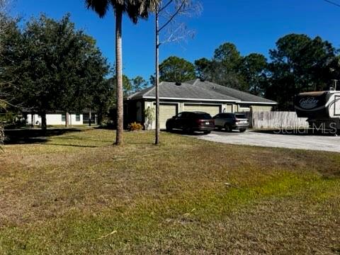 A single-story house with a two-car garage and a parked RV on a grassy lot — 845 10TH AVENUE NE, NAPLES, FL