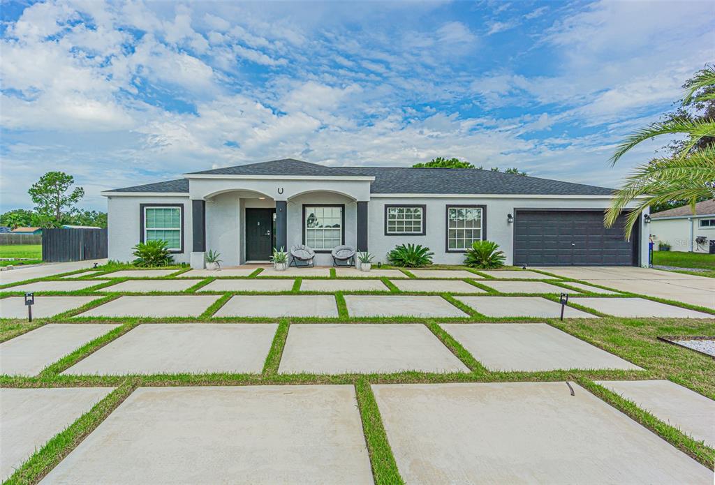 A single-story house with a gray exterior, a two-car garage, and a paved driveway — 12121 COLONIAL ESTATES LANE, RIVERVIEW, FL