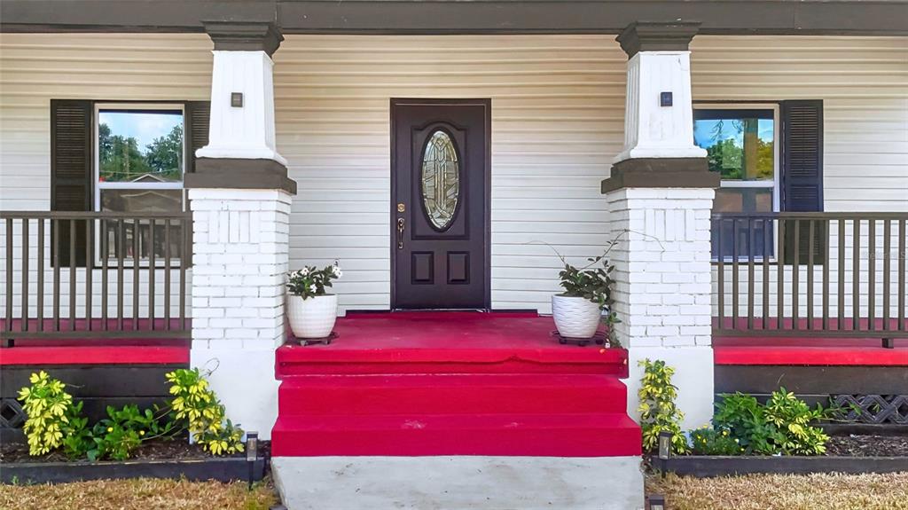 The front exterior of a house features a porch with white columns and red stairs — 2610 W CYPRESS STREET, TAMPA, FL