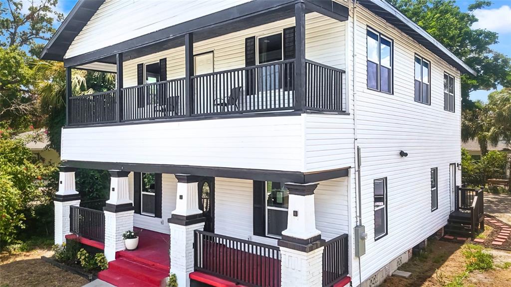 A two-story white house with black trim, a front porch, and an upper-level balcony — 2610 W CYPRESS STREET, TAMPA, FL
