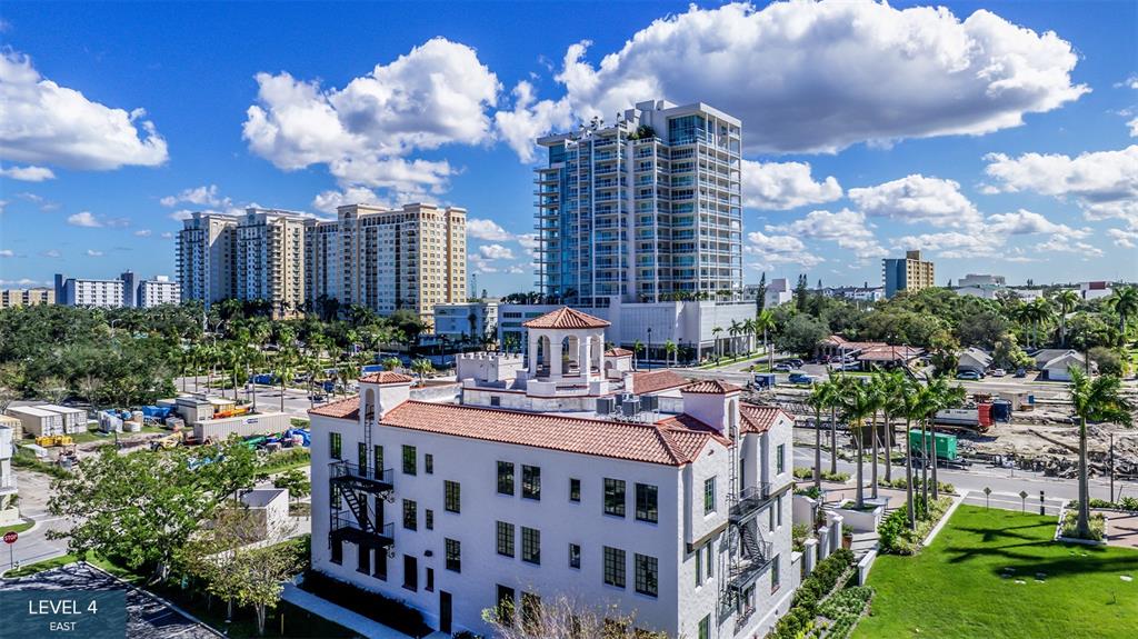 An aerial view shows a white building with a red tile roof and fire escapes — 555 QUAY COMMON UNIT 401, SARASOTA, FL