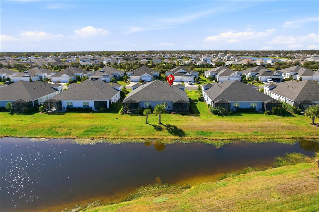 An aerial view shows a row of suburban houses with screened lanais overlooking a pond — 14530 BAREFOOT LANE, PARRISH, FL