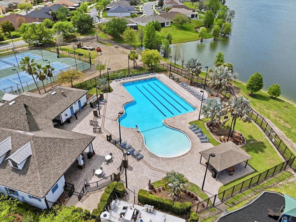An aerial view shows a suburban neighborhood with houses surrounding a large lake — 6431 COMO PLACE, LAKELAND, FL
