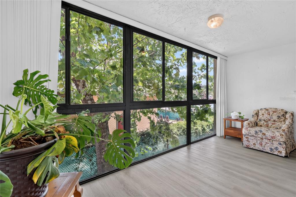 A dark-framed storm door leads to a covered exterior walkway with textured stucco walls — 1130 N LAKE PARKER AVENUE UNIT E233, LAKELAND, FL