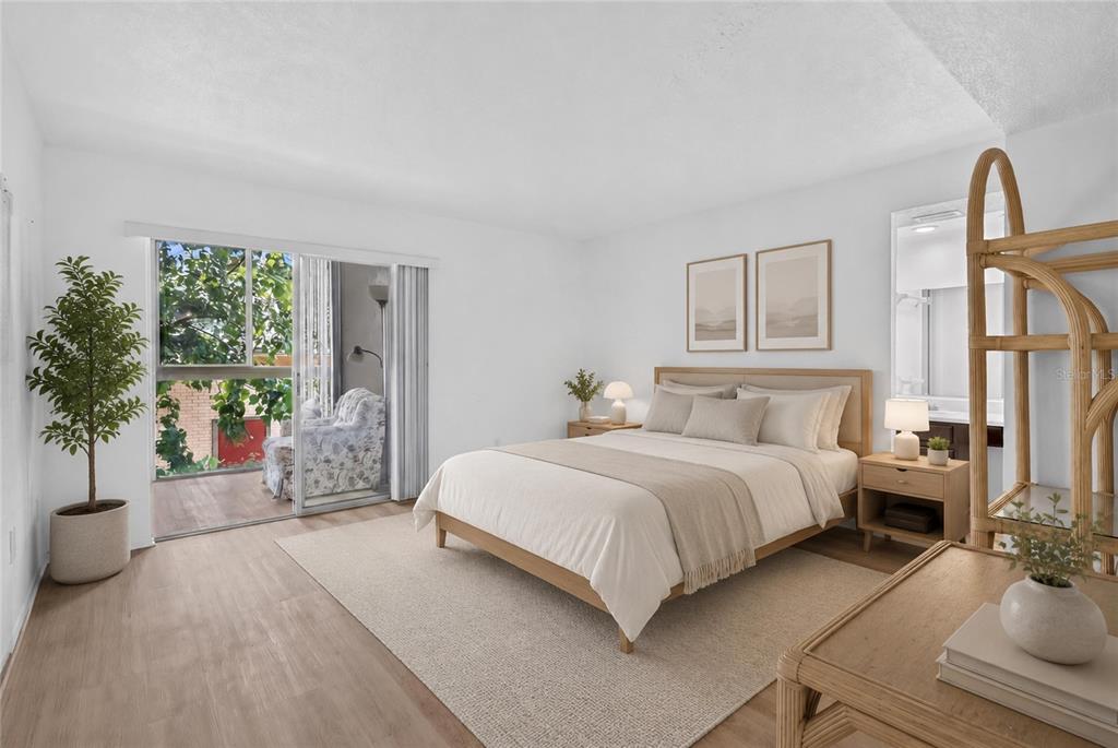 A living room with light wood flooring, floral sofas, and an adjacent dining area — 1130 N LAKE PARKER AVENUE UNIT E233, LAKELAND, FL