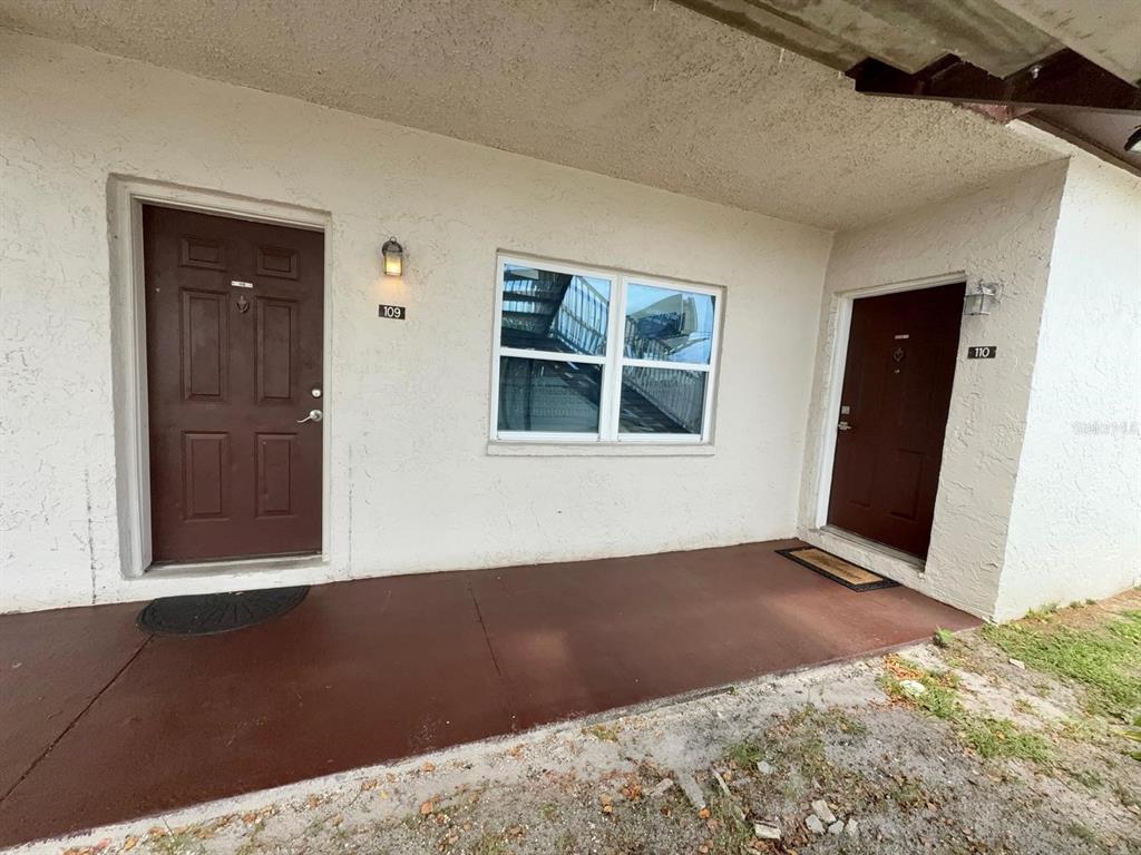 The exterior view shows two brown apartment doors numbered 109 and 110 with a window — 9109 W HILLSBOROUGH AVENUE UNIT J109, TAMPA, FL