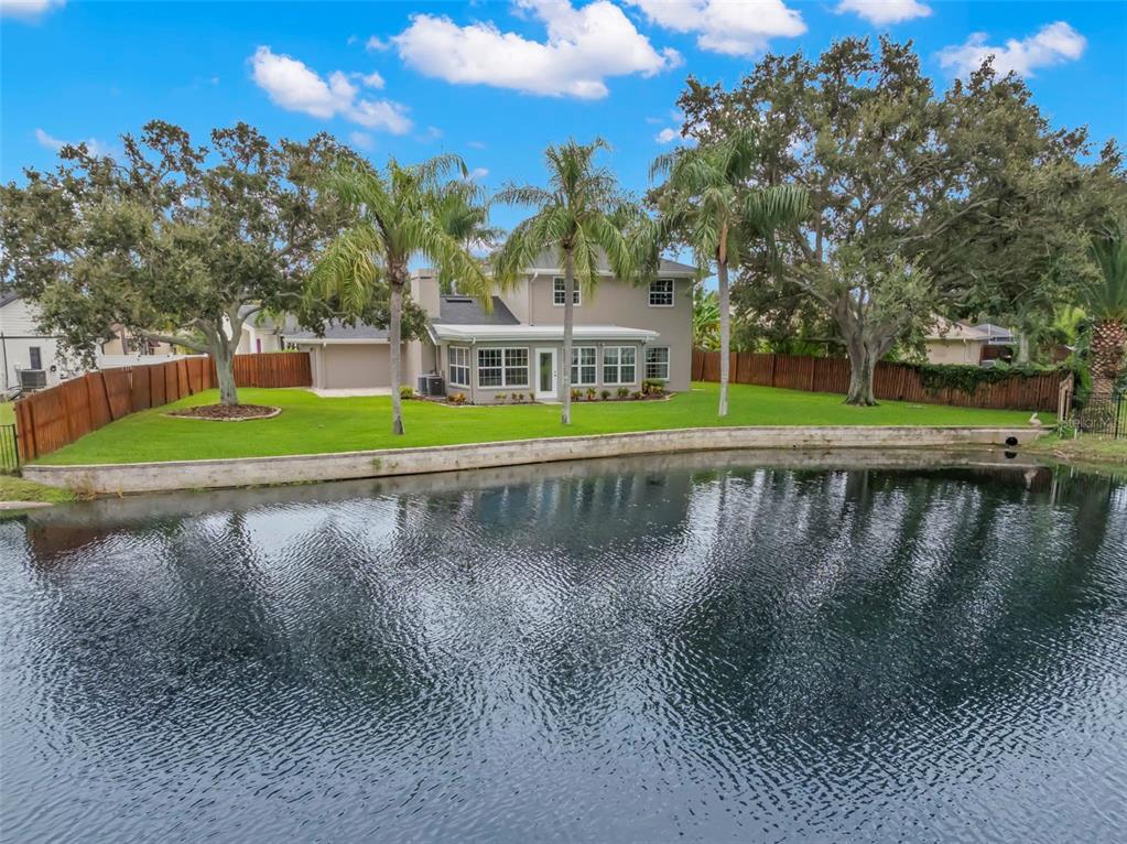 A two-story house with a garage, palm trees, and a manicured lawn under a blue sky — 1747 87TH TERRACE N, ST PETERSBURG, FL