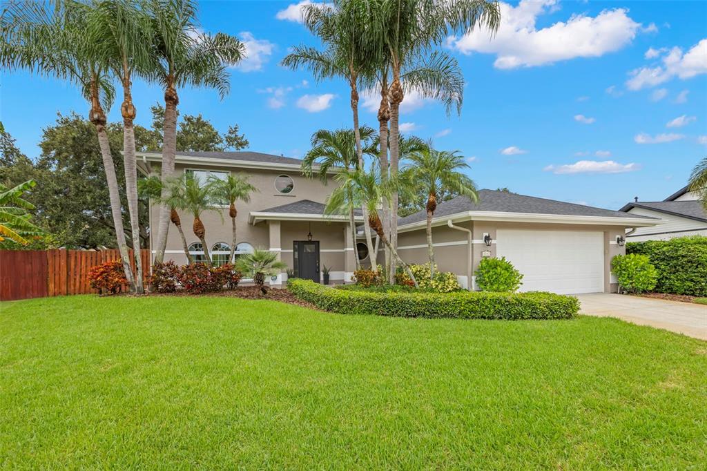 An aerial view of a two-story house with a garage, palm trees, and a backyard pond — 1747 87TH TERRACE N, ST PETERSBURG, FL