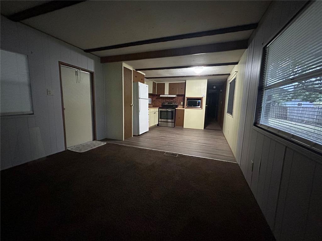 A bedroom features a bed with striped bedding, a yellow blanket, and a desk chair — 9640 SE 161ST PLACE, SUMMERFIELD, FL