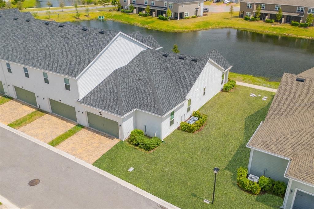 An aerial view shows a white townhouse with a gray roof, garages, and a pond — 43 TYSON COURT, ST AUGUSTINE, FL