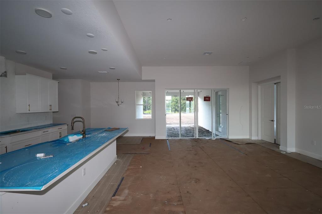 An unfinished room with exposed wooden wall studs, roof trusses, and subflooring under construction — 3011 SOLACE WAY, ORLANDO, FL