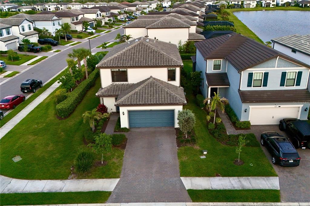 An aerial view shows a two-story suburban house with a tiled roof and paved driveway — 6111 BLUESTAR COURT, LAKEWOOD RANCH, FL