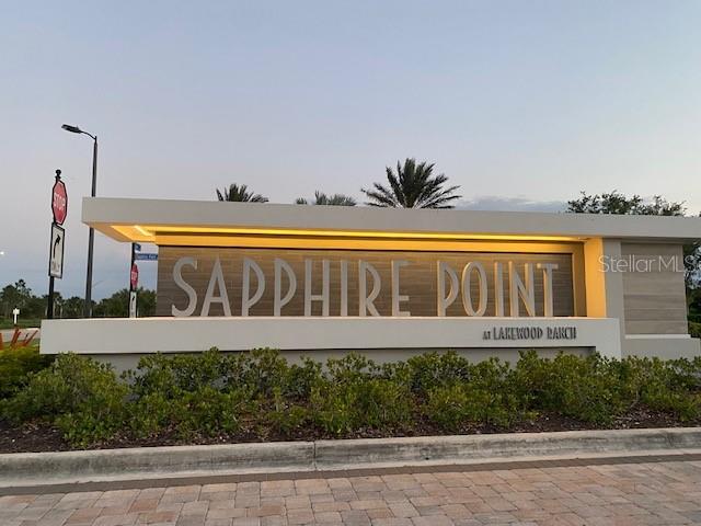 A modern entrance sign for Sapphire Point at Lakewood Ranch stands outdoors at dusk — 6111 BLUESTAR COURT, LAKEWOOD RANCH, FL