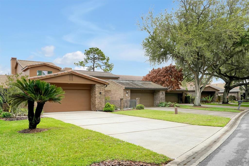 A residential street view showing two attached houses with brown garages and driveways — 139 WODEN WAY, WINTER HAVEN, FL