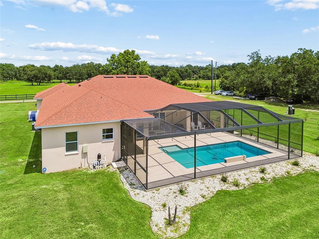 A spacious open-concept living room features white tile floors, a tray ceiling, and a kitchen — 8552 BRANDING IRON TRAIL, PLANT CITY, FL