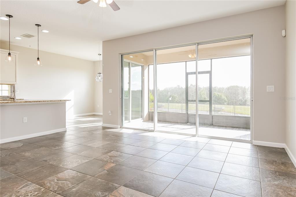 A tiled living area features a kitchen island and large sliding glass doors to a patio — 2270 NATOMA BOULEVARD, MOUNT DORA, FL