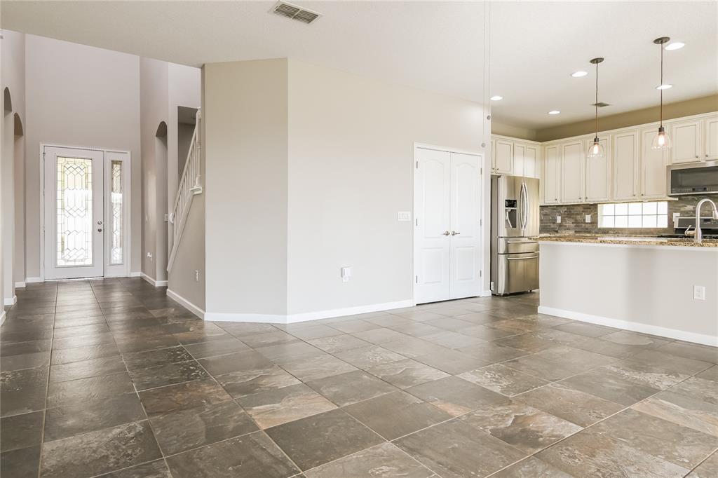 A view of a tiled entryway leading to a kitchen with white cabinets and appliances — 2270 NATOMA BOULEVARD, MOUNT DORA, FL