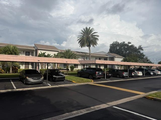 A parking lot with covered carports in front of a multi-story apartment building — 105 LAKEVIEW WAY UNIT 105, OLDSMAR, FL