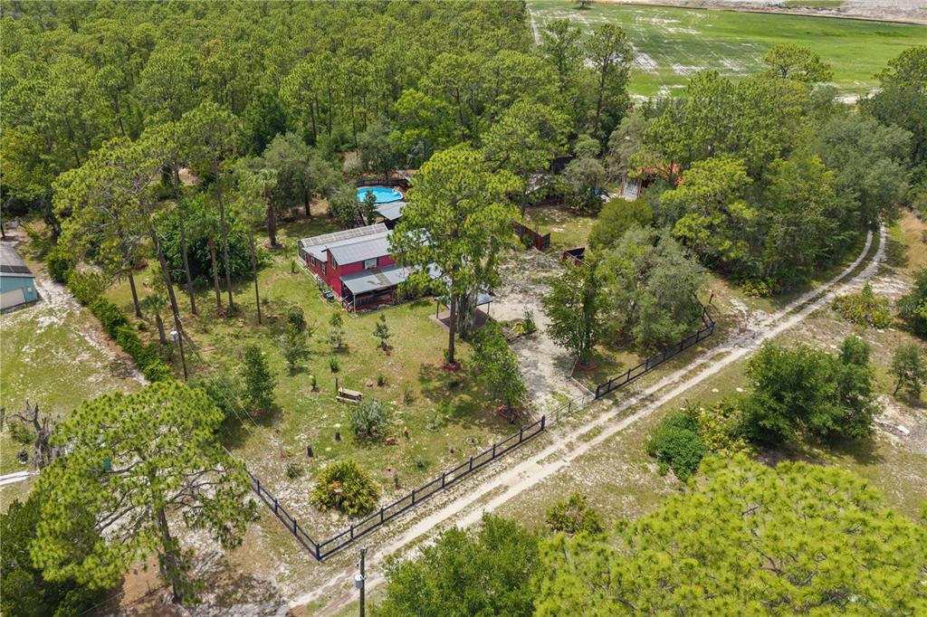 A red two-story house with a covered patio and a detached shed in a yard — 5080 N ALEXA TERRACE, CRYSTAL RIVER, FL
