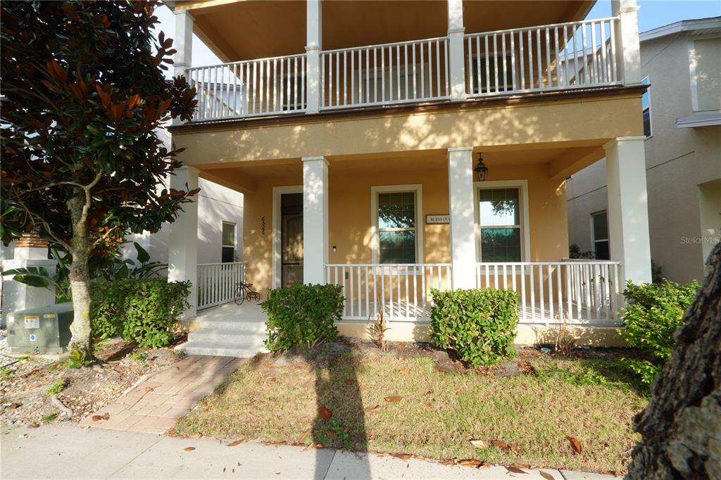 A kitchen with dark cabinets, granite countertops, and stainless steel appliances opens to a living area — 6526 GOLDEN DEWDROP TRAIL, WINDERMERE, FL