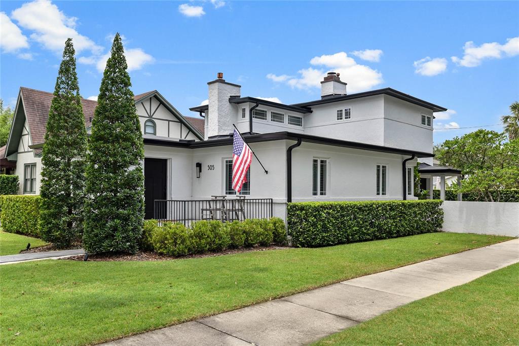 A white two-story house features a front porch, a chimney, and a manicured hedge — 505 WESTMINSTER STREET, ORLANDO, FL