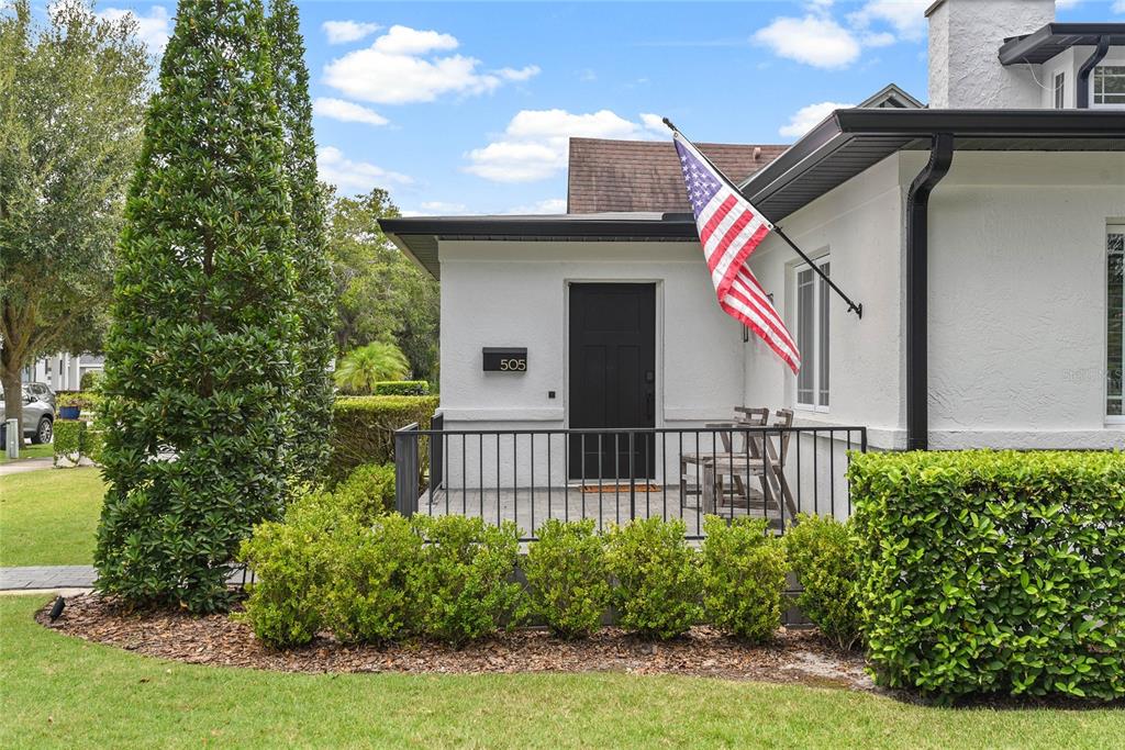 A white house exterior features a black front door, a porch with railings, and an American flag — 505 WESTMINSTER STREET, ORLANDO, FL