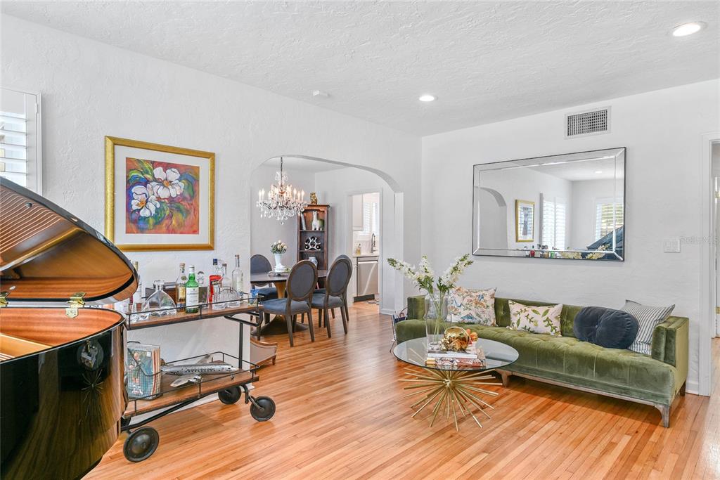 A living room with a green velvet sofa, a bar cart, and a grand piano — 505 WESTMINSTER STREET, ORLANDO, FL