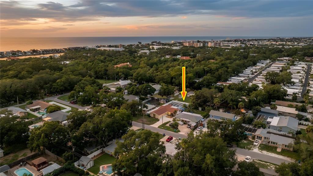 A single-story house with a stone accent wall, light-colored siding, and a concrete driveway — 14803 SUNSET DRIVE, LARGO, FL