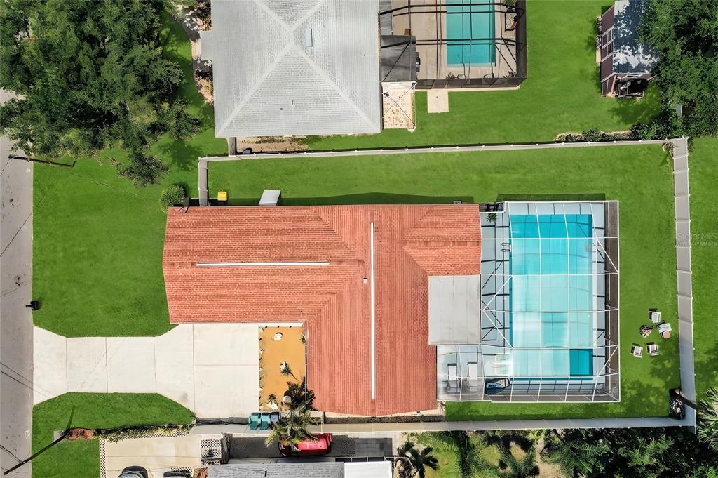 An aerial view shows a residential neighborhood with houses, swimming pools, and dense trees — 14803 SUNSET DRIVE, LARGO, FL