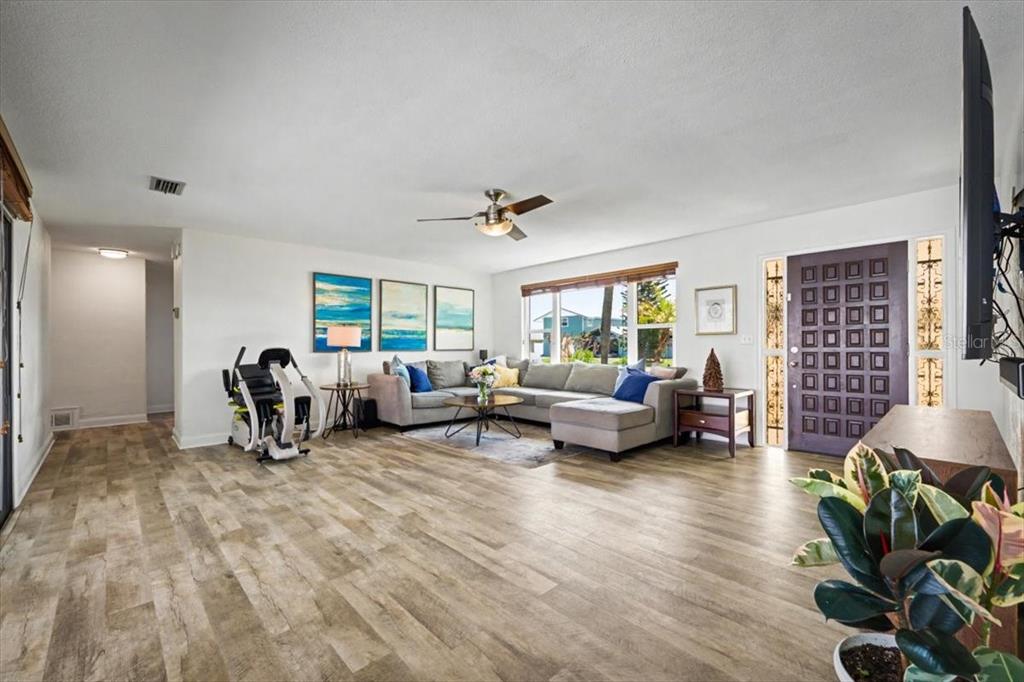 A living room features light wood-look flooring, a sectional sofa, and a dark front door — 124 ANCHOR DRIVE, PONCE INLET, FL