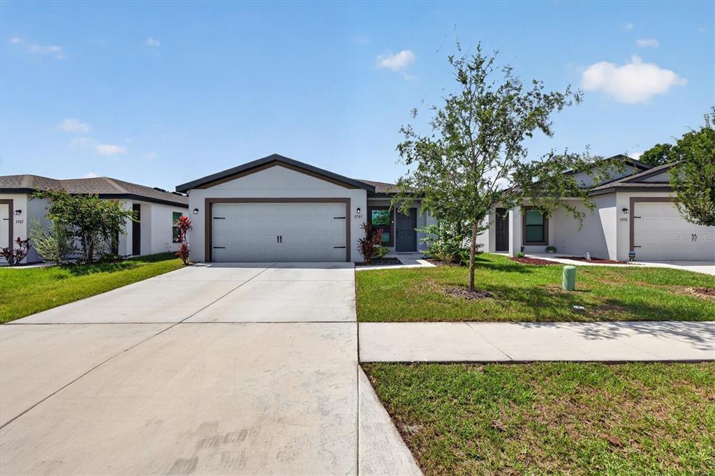 A single-story suburban house with a two-car garage and a concrete driveway — 5761 HELMSMAN COURT, TAMPA, FL