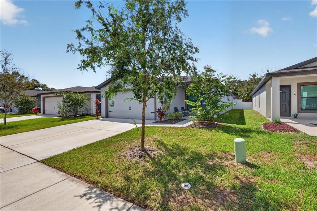 A single-story house with a two-car garage, a concrete driveway, and a front yard — 5761 HELMSMAN COURT, TAMPA, FL