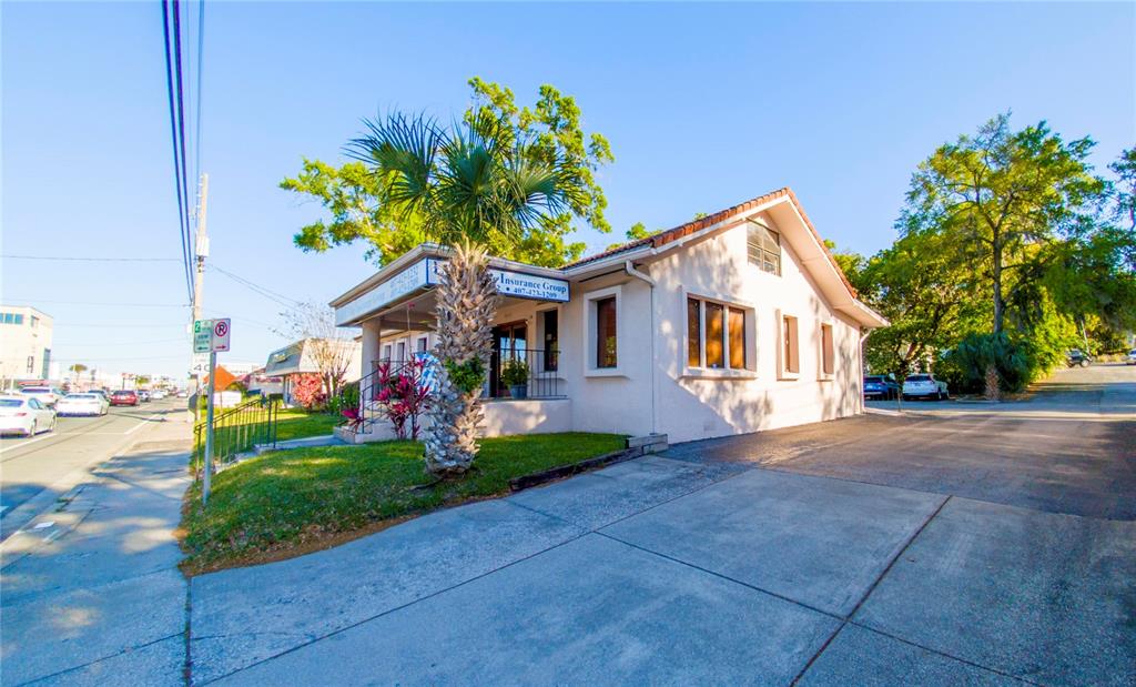 A single-story commercial building with a palm tree, a paved driveway, and a small porch — 802 E COLONIAL DRIVE, ORLANDO, FL