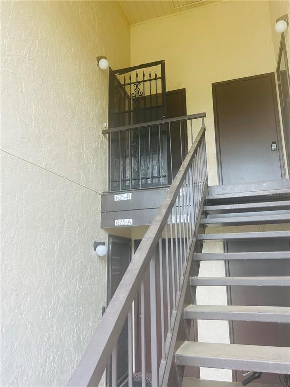 An exterior view shows a metal staircase leading to two apartment unit doors — 625 MIDWAY DRIVE UNIT B, OCALA, FL