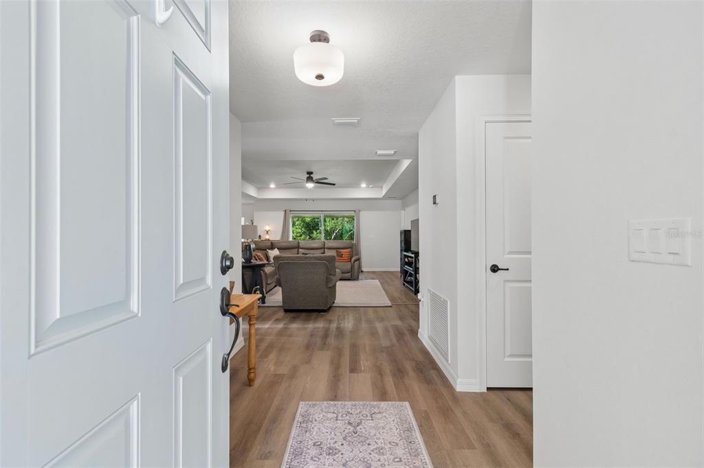 A single-story house exterior features a light-colored stucco facade, a garage, and a recessed entryway — 8948 CARRIE WAY, WEEKI WACHEE, FL