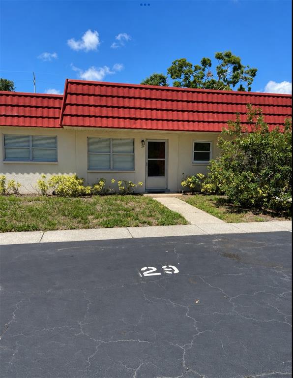 A single-story apartment building with a red roof and a sidewalk across a lawn — 5860 38TH AVENUE N UNIT 29, ST PETERSBURG, FL
