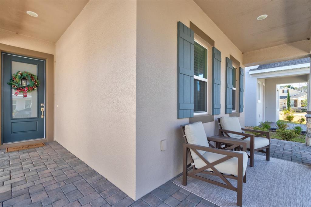 A covered front porch features a dark door, two chairs, and blue window shutters — 828 MIDDLETON STREET, DEBARY, FL