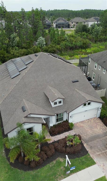 An aerial view shows a single-family home with a shingled roof and solar panels — 19206 BRIARBROOK DRIVE, TAMPA, FL