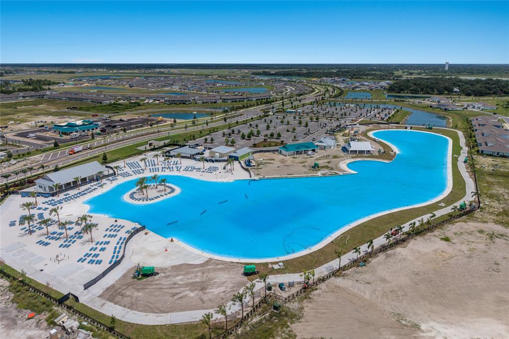An aerial view of a large, bright blue man-made swimming lagoon surrounded by lounge chairs — 8924 DEEP HORIZON LOOP, PARRISH, FL