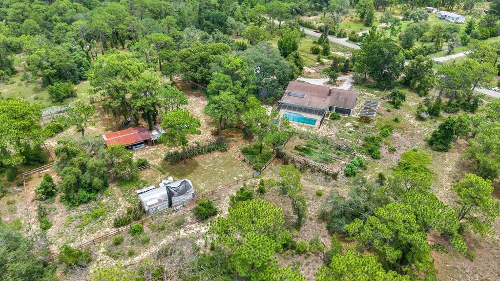 An aerial view shows a house with a pool, a shed, and a greenhouse — 11251 SALINA STREET, BROOKSVILLE, FL