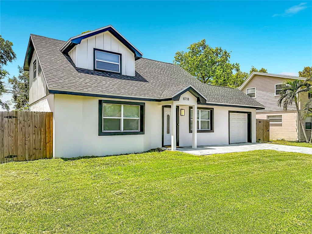 A white two-story house with a dark roof, a front porch, and a grassy lawn — 8718 94TH ST, SEMINOLE, FL