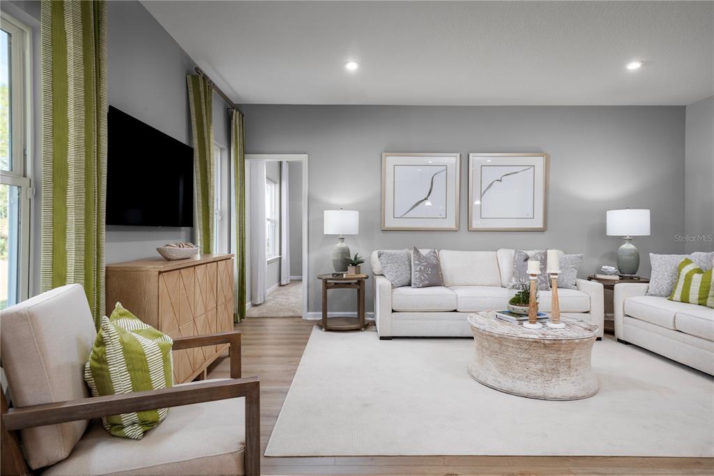 A living room features a white sofa, two armchairs, a coffee table, and green curtains — 1016 OCEAN LODGE ROAD, LADY LAKE, FL