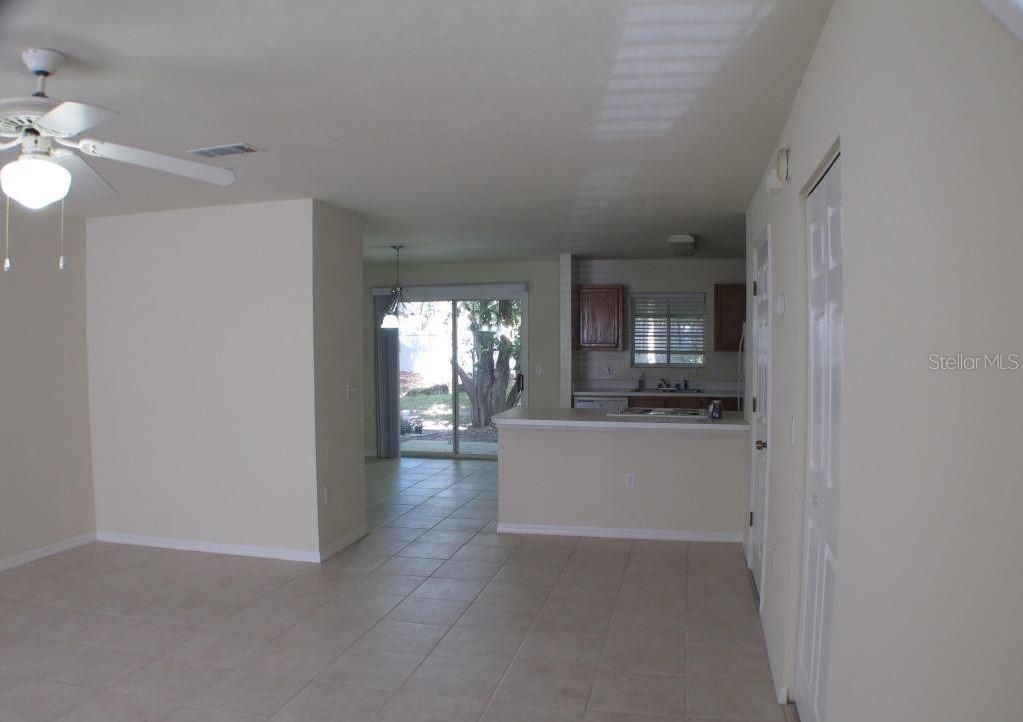 An open-concept living area with tile flooring, a ceiling fan, and a kitchen with a breakfast bar — 5205 SW 97TH DRIVE, GAINESVILLE, FL