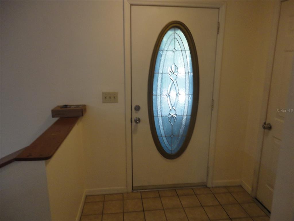 An entryway features a white door with an oval glass insert and tiled flooring — 7823 SW 9TH PLACE, GAINESVILLE, FL