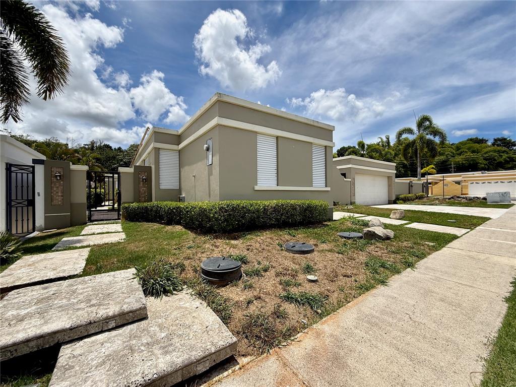 A single-story house with a flat roof, beige stucco walls, and a front yard — 834 CALLE 3 UNIT B13, GUAYNABO, PR