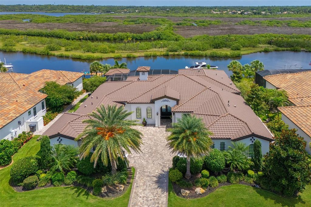 An aerial view shows a single-story house with a tile roof and a paved driveway — 11424 HARBOURSIDE LANE, PARRISH, FL