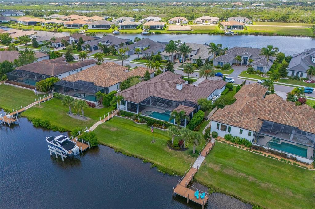 An aerial view shows waterfront houses with swimming pools, screened lanais, and private boat docks — 11424 HARBOURSIDE LANE, PARRISH, FL