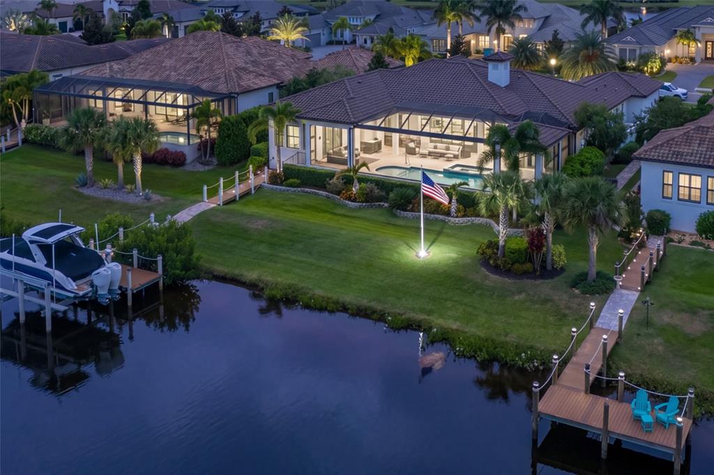 An aerial view of a waterfront house with a pool, boat dock, and flag pole — 11424 HARBOURSIDE LANE, PARRISH, FL