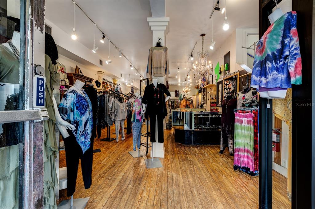 A retail clothing store interior features hardwood floors, mannequins, and hanging racks of apparel — 427 N DONNELLY STREET, MOUNT DORA, FL